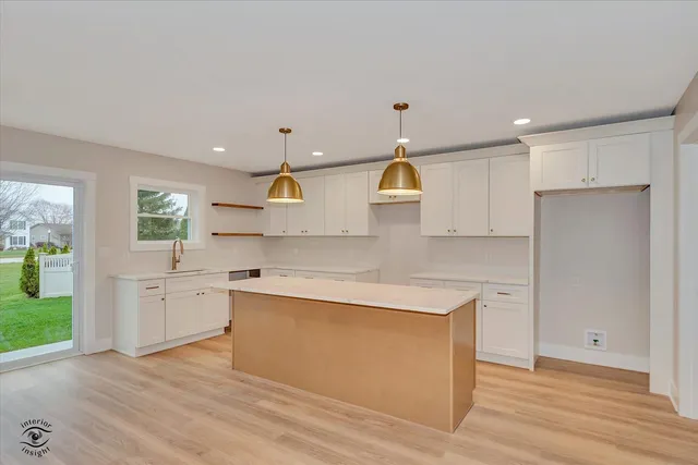 a kitchen with a sink a stove cabinets and wooden floor