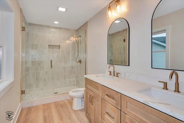 a bathroom with a double vanity sink toilet and shower