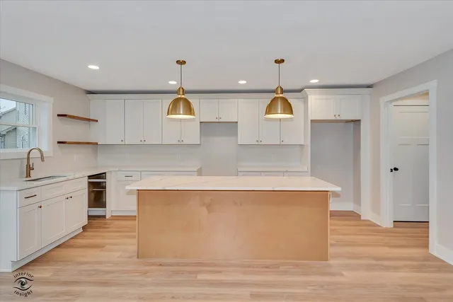 a kitchen with stainless steel appliances granite countertop a sink a stove and a refrigerator