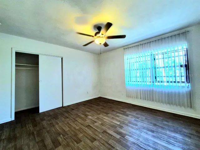 a view of empty room with wooden floor