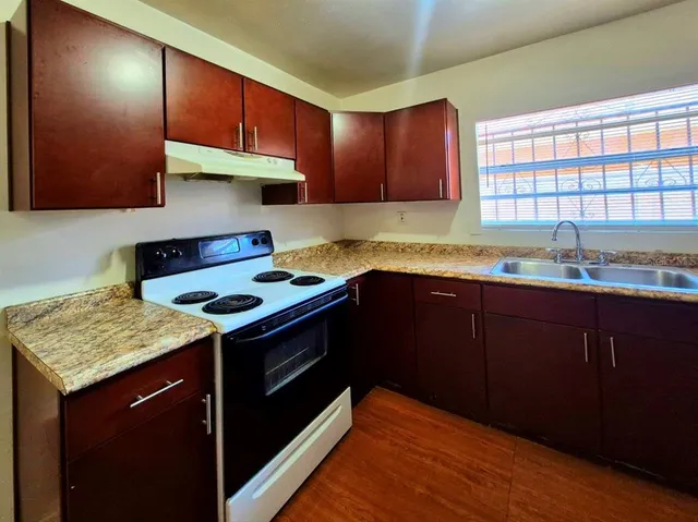 a kitchen with granite countertop wood cabinets and stainless steel appliances