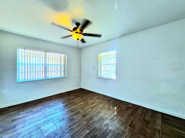 a view of a big room with wooden floor and a ceiling fan