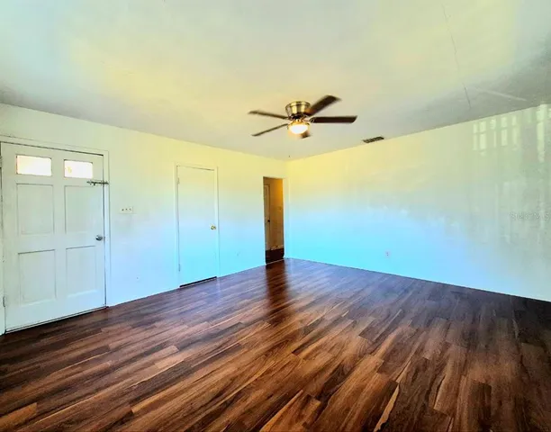 a view of empty room with wooden floor