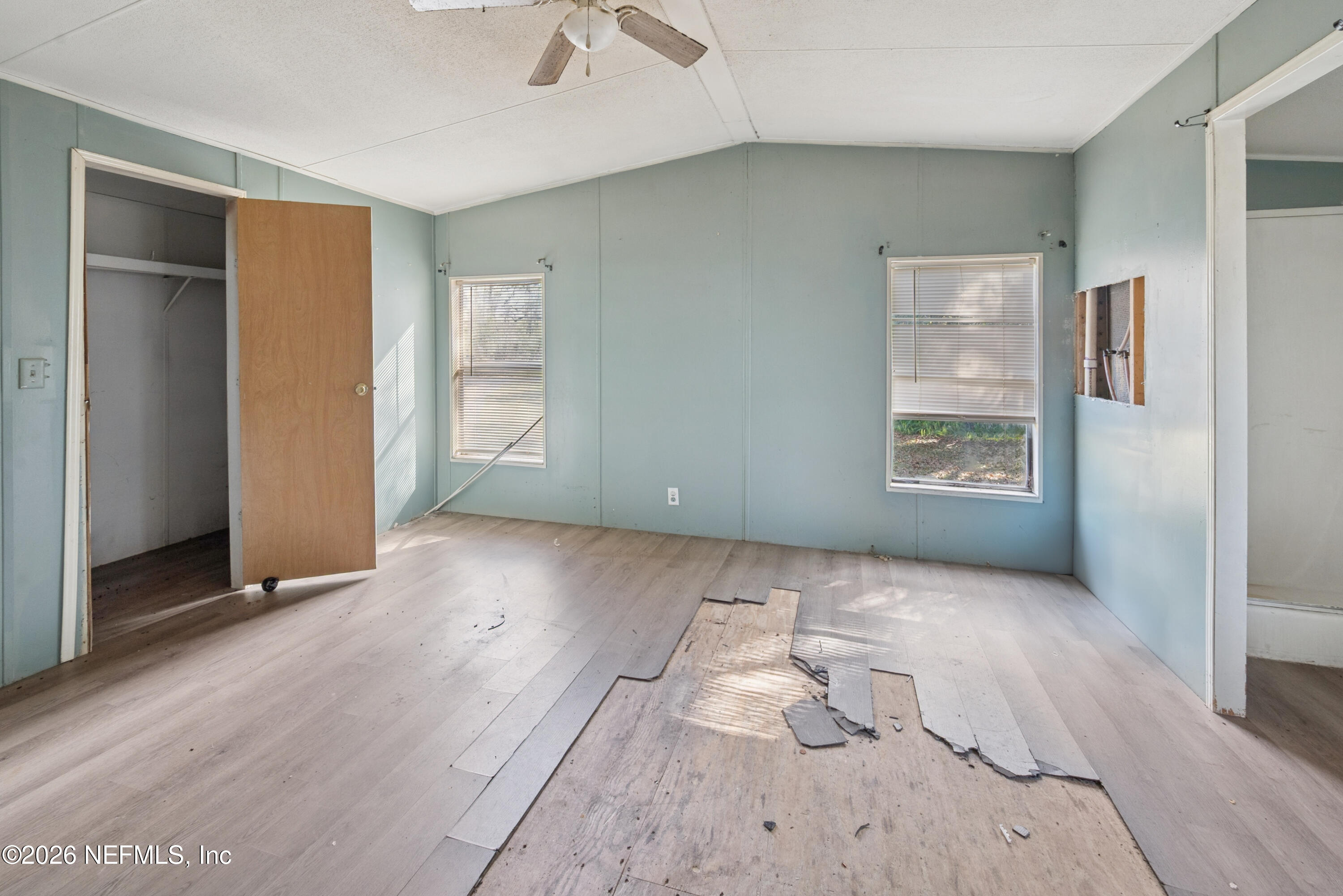 9860 State Rte 100 Starke, FL 32091 - Photo 19 of 24 an empty room with wooden floor and windows