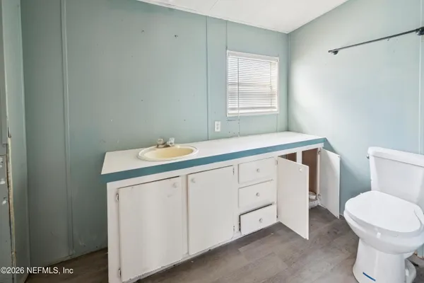a bathroom with a sink a toilet and window