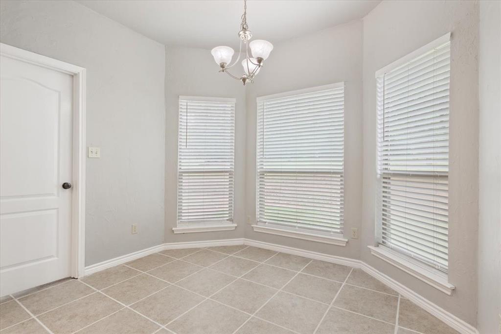 140 Oak Ridge Loop Whitney, TX 76692 - Photo 12 of 40 This room features tiled flooring, a bay window with three windows and blinds, and a white paneled door