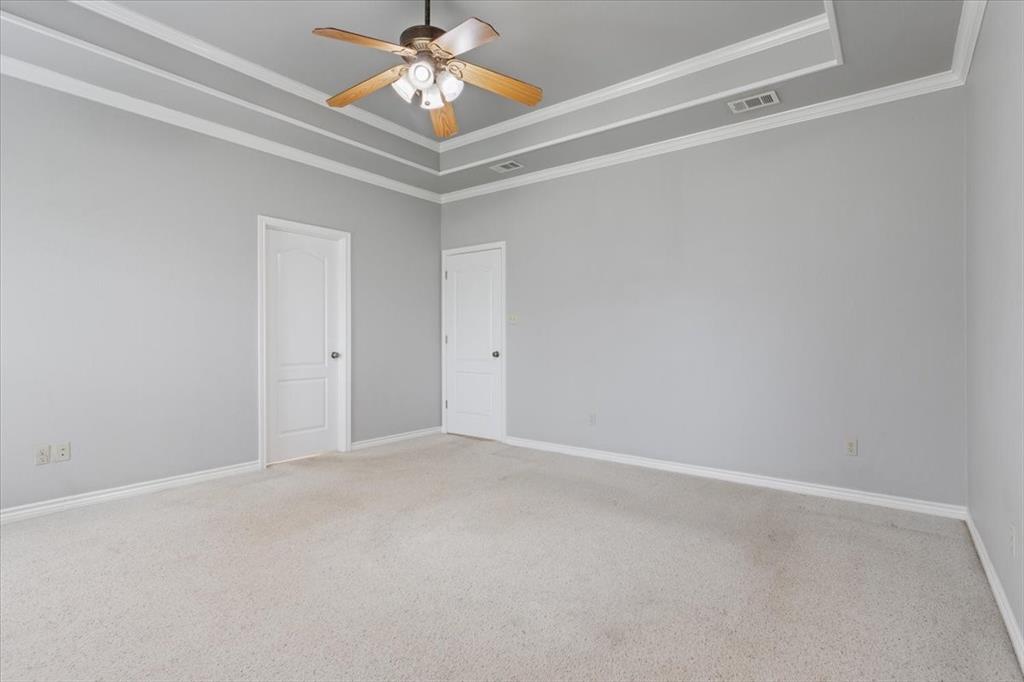 140 Oak Ridge Loop Whitney, TX 76692 - Photo 21 of 40 Spacious room featuring light gray walls, carpeted floors, and a tray ceiling with crown molding and a ceiling fan