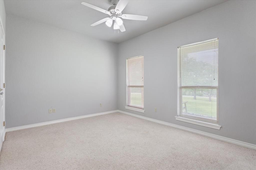 140 Oak Ridge Loop Whitney, TX 76692 - Photo 27 of 40 The room features carpeted floors, light grey walls, and white trim