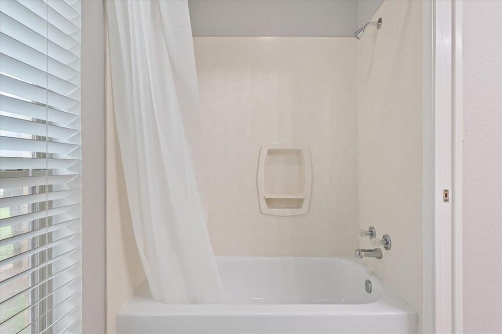 140 Oak Ridge Loop Whitney, TX 76692 - Photo 31 of 40 Bathroom featuring a white bathtub with a shower and a window with blinds