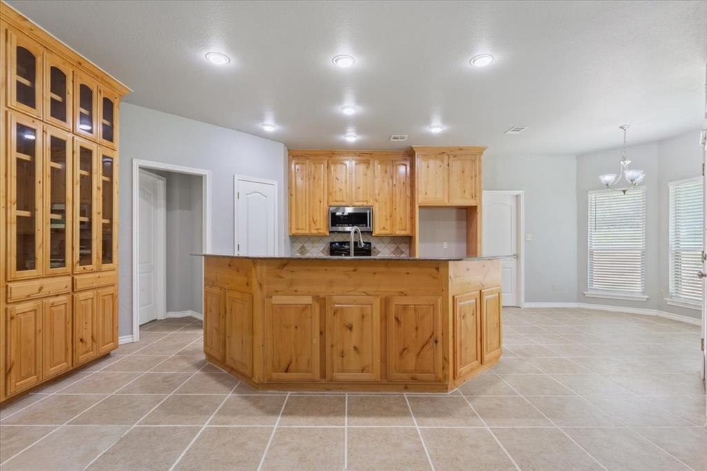 140 Oak Ridge Loop Whitney, TX 76692 - Photo 10 of 40 The kitchen features ample light wood cabinetry, including a large built-in hutch with glass-fronted doors