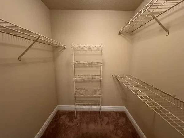 a view of walk in closet with clothes