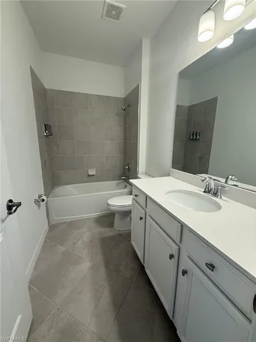 a bathroom with a double vanity sink toilet mirror and bathtub