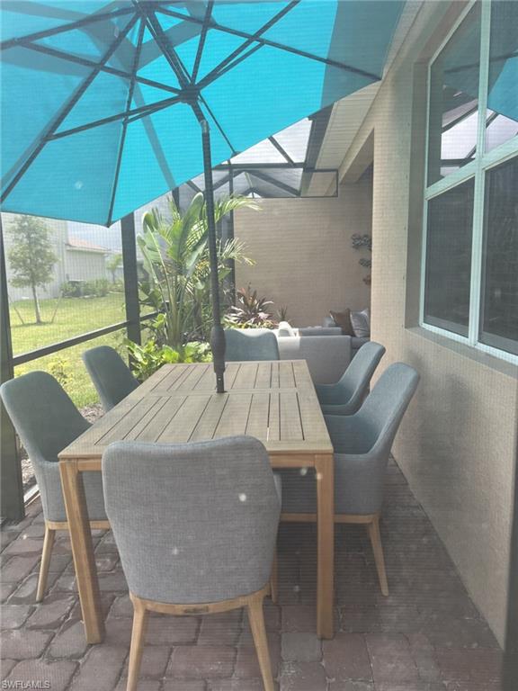 2648 Vine Avenue Naples, FL 34120 - Photo 17 of 20 a view of an outdoor sitting area with furniture and umbrella