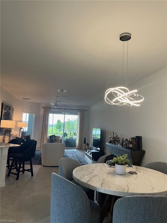 2648 Vine Avenue Naples, FL 34120 - Photo 3 of 20 a view of a dining room with furniture and a chandelier
