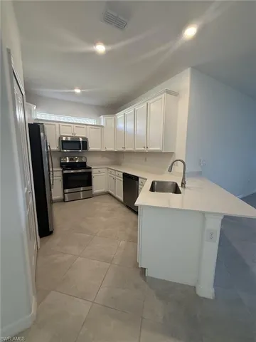 a kitchen with kitchen island a sink stainless steel appliances and cabinets