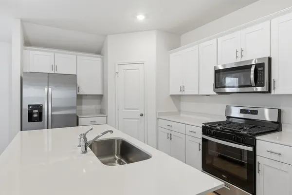 a kitchen with sink a microwave and cabinets