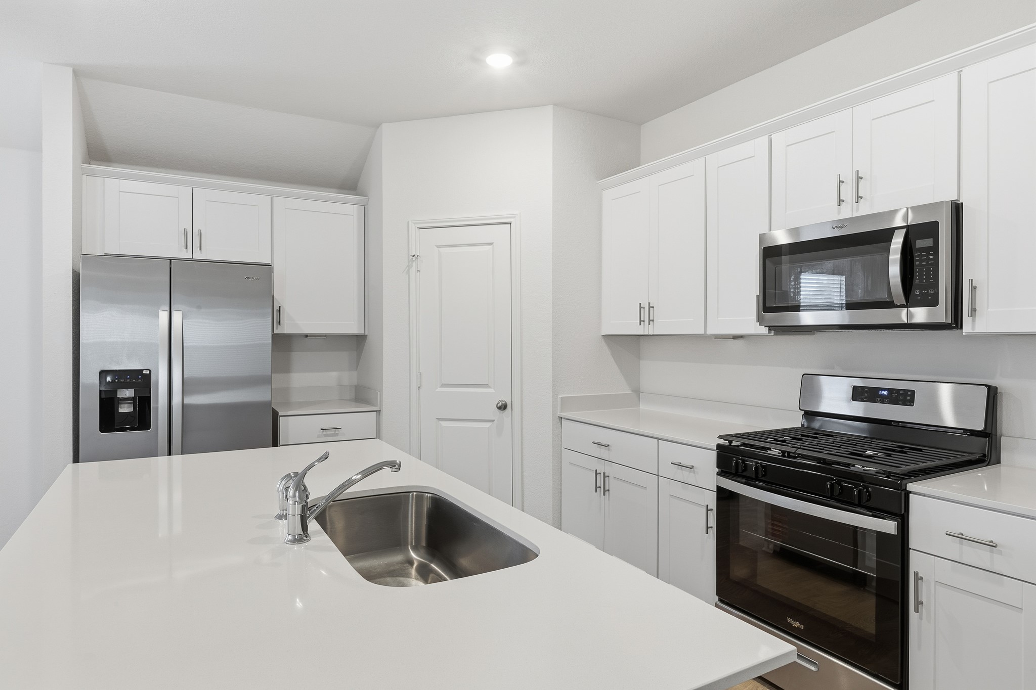 a kitchen with sink a microwave and cabinets