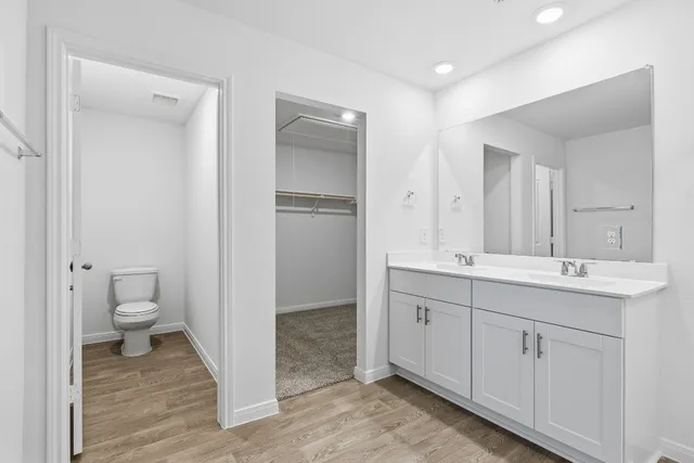 a spacious bathroom with a toilet sink and mirror