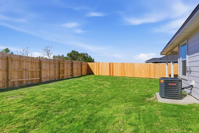 a view of a backyard with wooden fence