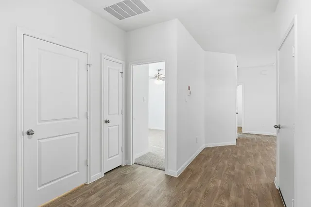 a view of hallway with wooden floor