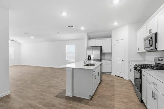 a kitchen with stainless steel appliances granite countertop a sink stove and refrigerator