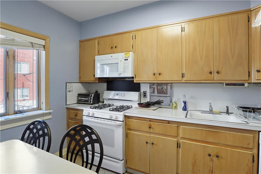 2815 Ave Y Brooklyn, NY 11235 - Photo 8 of 21 a kitchen with a stove a sink and a microwave