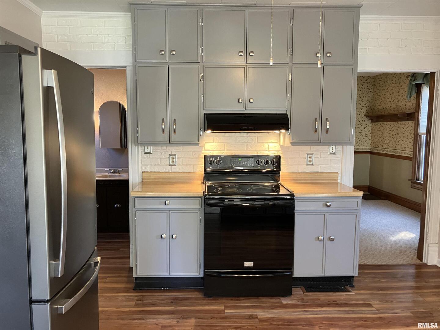 837 Beach Street Kewanee, IL 61443 - Photo 17 of 54 a kitchen with a refrigerator stove and wooden floor