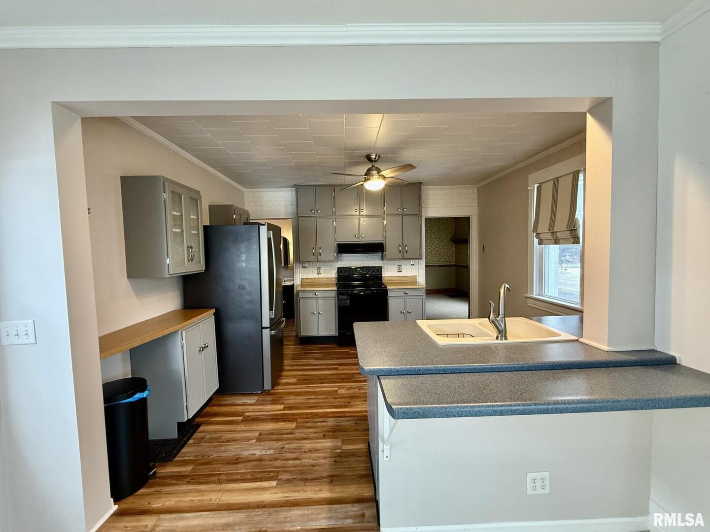 837 Beach Street Kewanee, IL 61443 - Photo 19 of 54 a kitchen with stainless steel appliances granite countertop a refrigerator a stove and a sink with wooden floor
