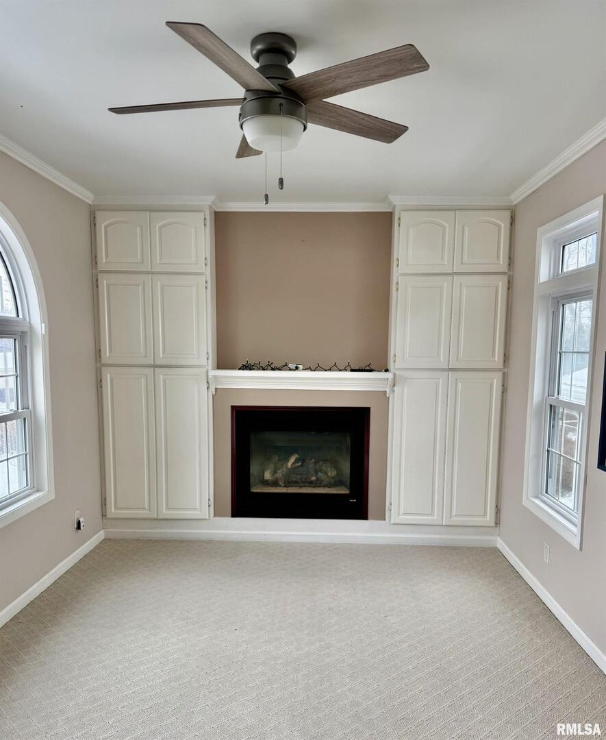 837 Beach Street Kewanee, IL 61443 - Photo 22 of 54 a living room with a fireplace and a ceiling fan