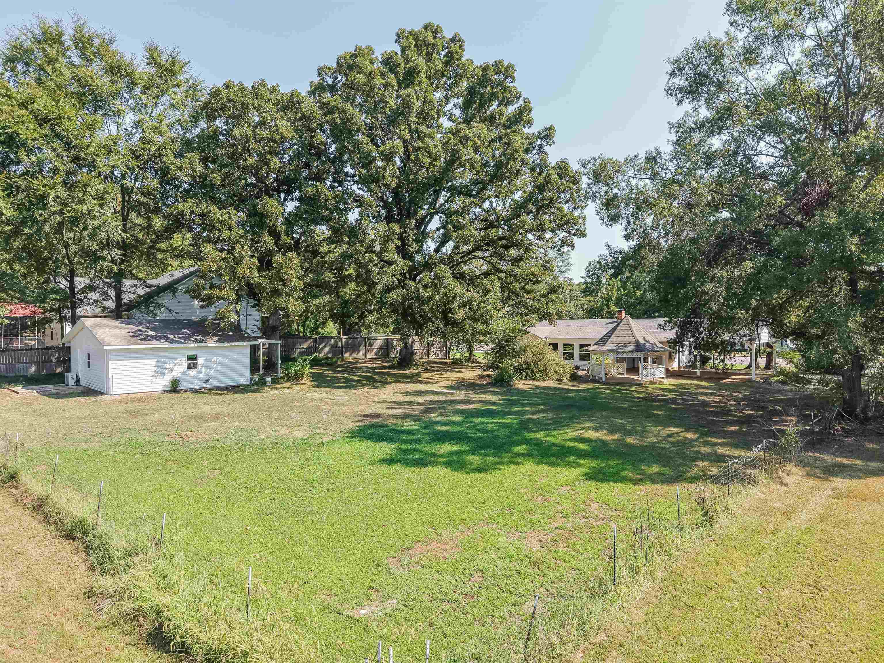 7437 Highway 45 Ramer, TN 38367 - Photo 8 of 36 Expansive green space featuring a large detached white shed with a gabled roof