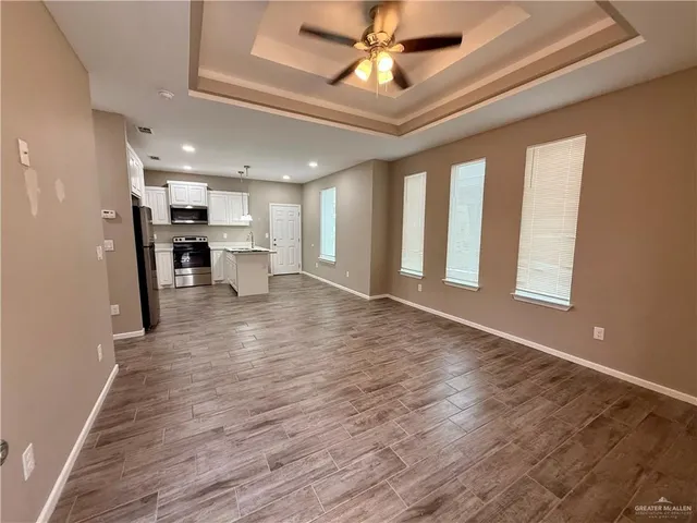 a view of a kitchen with wooden floor and a window