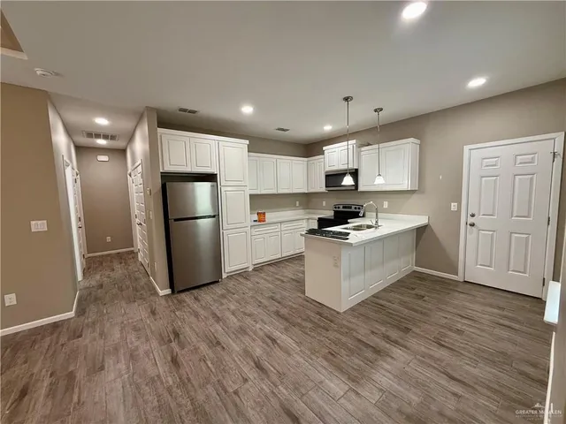 a kitchen with white cabinets and stainless steel appliances