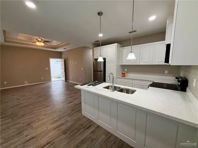 a kitchen with a sink a counter top space appliances and cabinets