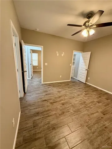 a view of a livingroom with wooden floor and a ceiling fan