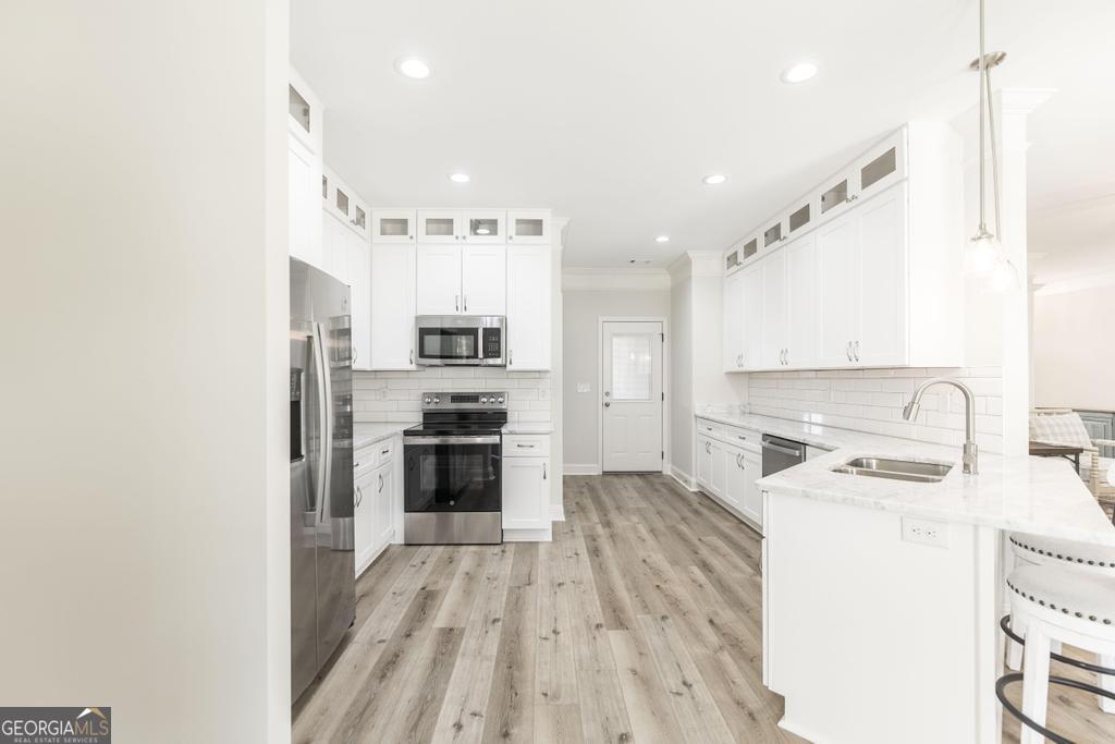 224 Otters Rdg Drive Kathleen, GA 31047 - Photo 13 of 31 a kitchen with stainless steel appliances a stove top oven a sink a refrigerator white cabinets and wooden floor