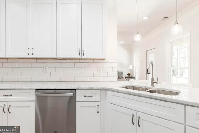 a kitchen with granite countertop white cabinets and a sink