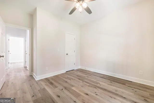 a view of a room with wooden floor and ceiling fan