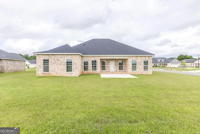 a front view of a house with a garden and lake view
