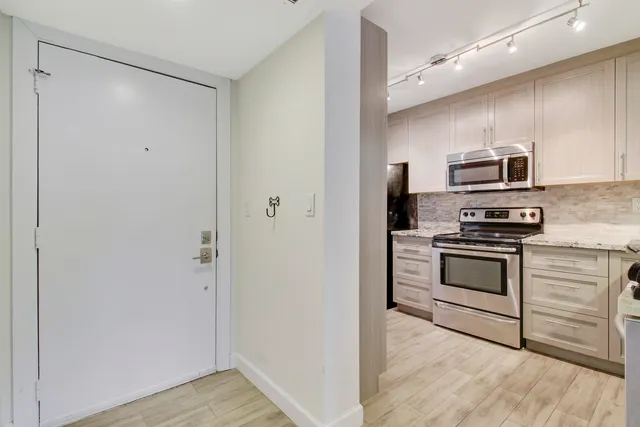 a kitchen with stainless steel appliances granite countertop a stove microwave and refrigerator