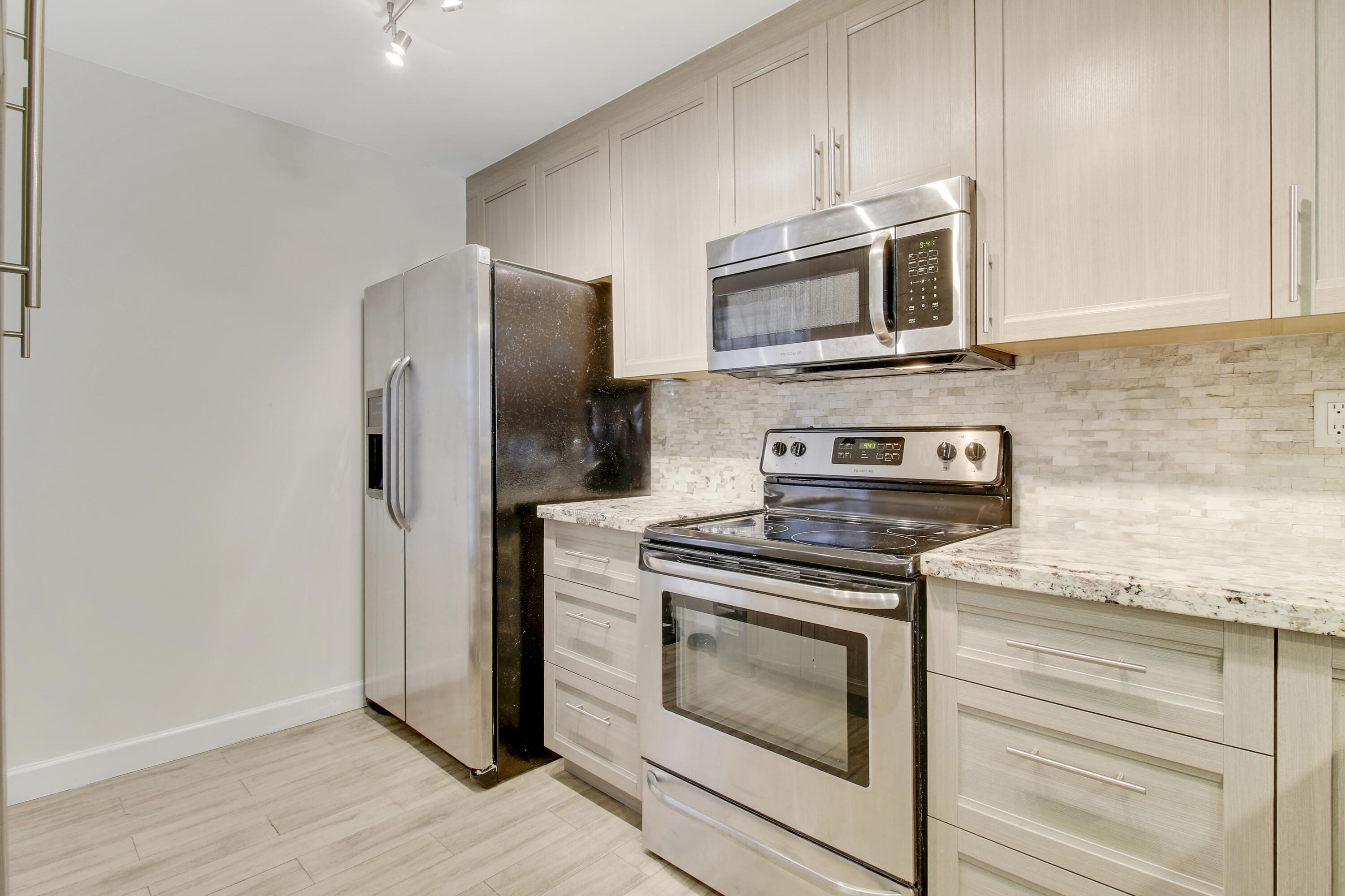 9 Royal Palm Way, Unit 105 Boca Raton, FL 33432 - Photo 4 of 26 a kitchen with stainless steel appliances granite countertop a stove microwave and refrigerator