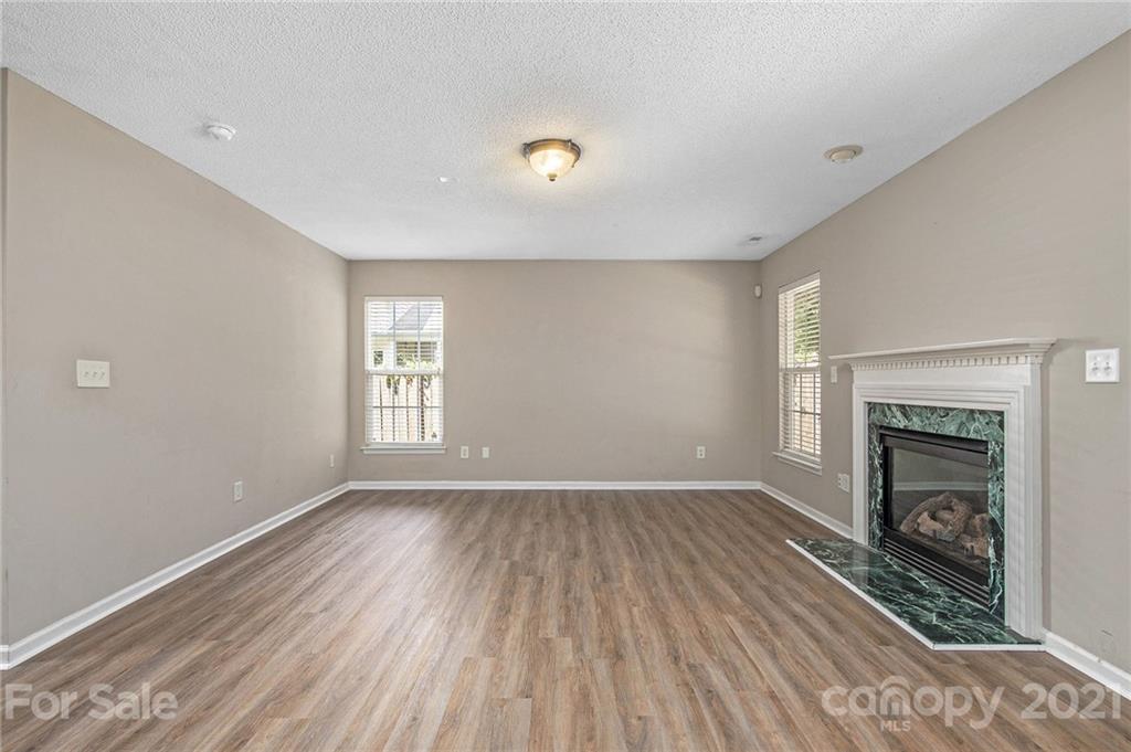 521 Red Oak Court Tega Cay, SC 29708 - Photo 12 of 23 a view of empty room with wooden floor and fireplace