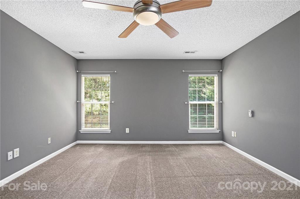 521 Red Oak Court Tega Cay, SC 29708 - Photo 15 of 23 an empty room with chandelier fan and windows