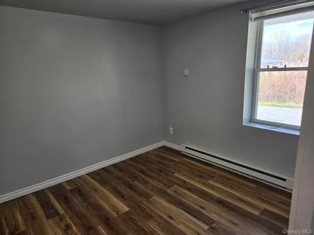 a view of a room with wooden floor and windows