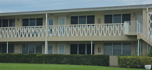 a view of a brick house with large windows and a yard