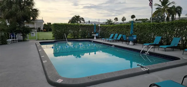 a view of a swimming pool with a patio and a yard
