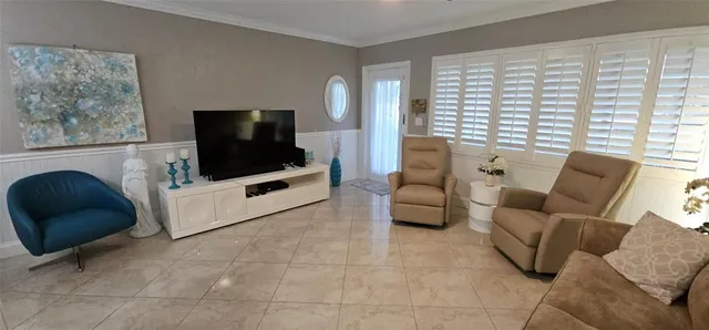 a room with table chairs and white cabinets