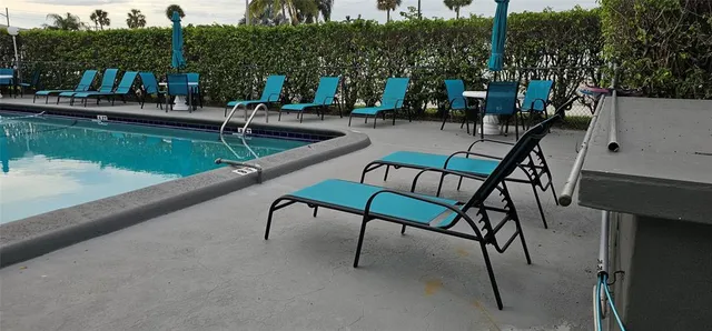 a view of swimming pool with outdoor seating and trees