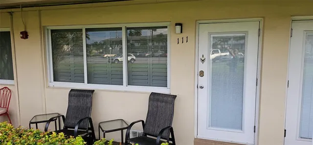 a living room with stainless steel appliances kitchen island granite countertop furniture and a large window