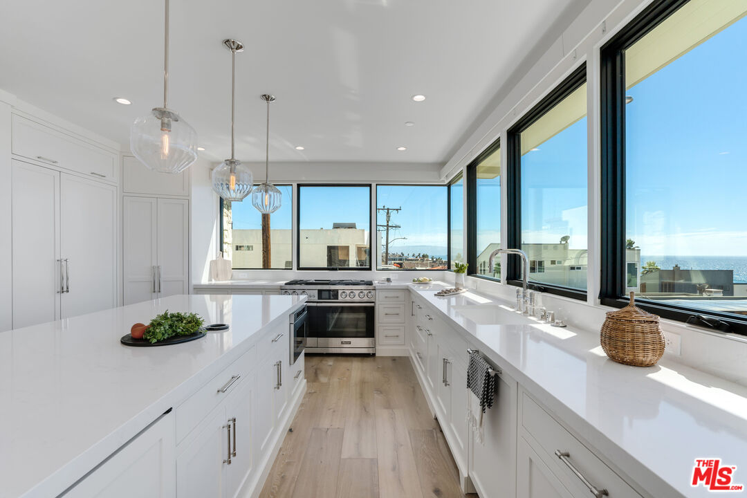 4314 Ocean Drive Manhattan Beach, CA 90266 - Photo 12 of 46 a large kitchen with stainless steel appliances a lot of counter space and a large window