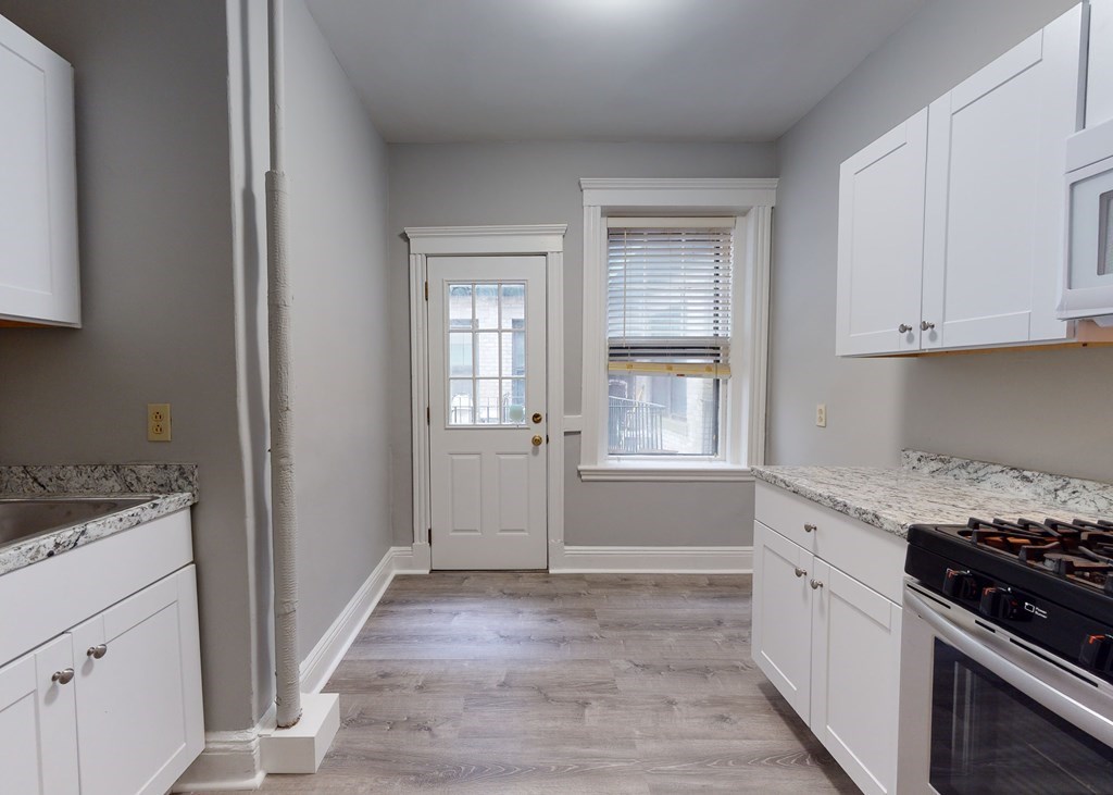 59 Lanark Road, Unit 4 Boston, MA 02135 - Photo 3 of 25 a kitchen with granite countertop cabinets appliances and a window